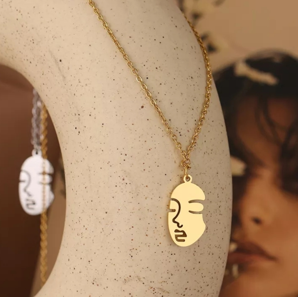 Gold colored stainless steel abstract art face imprint necklace